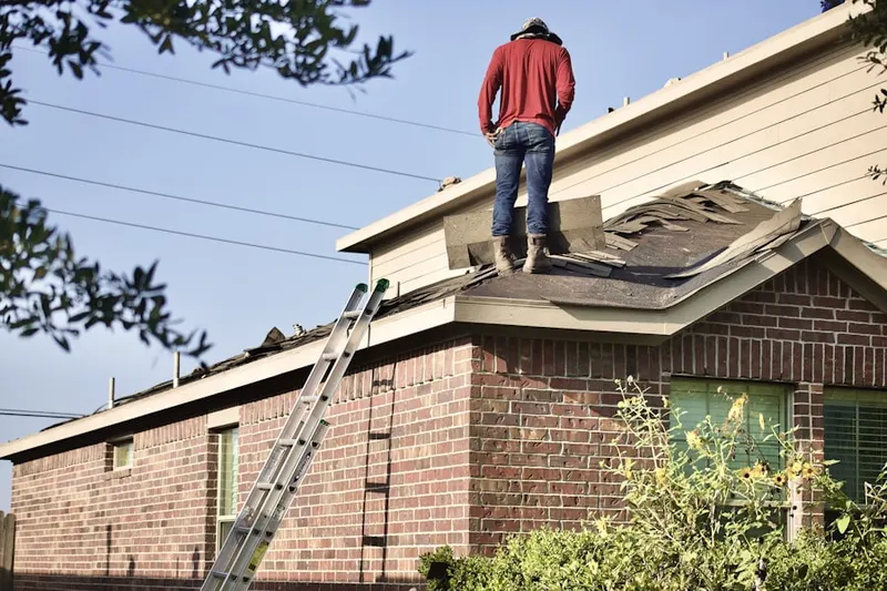 Professional roofer working on a residential roof in Schultzville